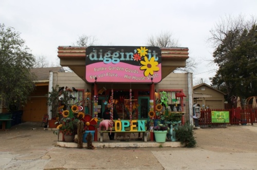 At first glance, Diggin' It's facade does not leave any trace of its past as a Greyhound bus station. However, with closer look, customers and passersby can see where the bus used to park in front of the store beneath the carport, which is now decked out in art and backyard decorations. (Francesca D'Annunzio/Community Impact Newspaper)