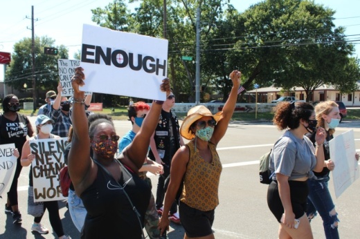 Protesters held signs and chanted as they walked down West Main Street in Tomball on June 13. (Anna Lotz/Community Impact Newspaper)