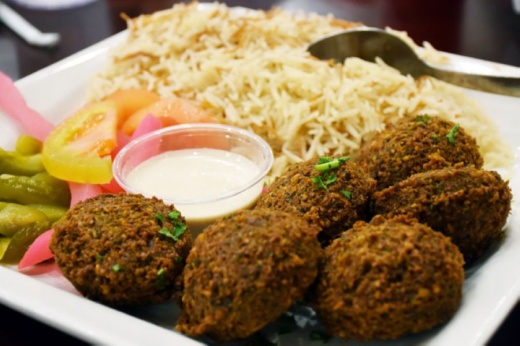 The falafel plate at Afrah Mediterranean Cuisine comes with tahini sauce and two sides. (Makenzie Plusnick/Community Impact Newspaper)