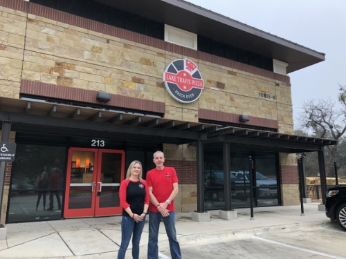 Leah and Mark Mirra stand in front of their upcoming location of Lake Travis Pizza in the River Place neighborhood. (Amy Rae Dadamo/Community Impact Newspaper)
