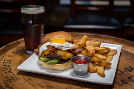 The fried egg burger ($13) is an 8 oz. beef burger on a brioche bun topped with a fried egg, bacon, avocado, cheddar cheese and caramelized onions, served with fries.