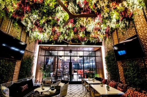 The restaurant expects to open this March with similar design elements to its Dallas location, such as an ivy-adorned garden patio and chandeliers over the bar. (Courtesy Ebb & Flow)