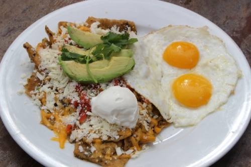 Rafaela’s Chilaquiles ($10.99) include custom-prepared eggs accompanied by a house tomatillo salsa verde, fried tortilla chips, cheddar and cotija cheeses, pico de gallo, avocado, sour cream and cilantro. Meat can also be added. (Ben Thompson/Community Impact Newspaper)