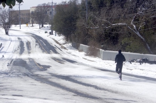 A jogger runs up a nearly deserted Manor Road in Austin on Feb. 16, two days after a winter storm dropped six inches of snow in the area. (Jack Flagler/Community Impact Newspaper) 