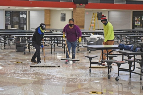 Restoration crews work to clean up water from the floors following freezing temperatures this week that caused pipe damage to campuses. (Courtesy Cy-Fair ISD)