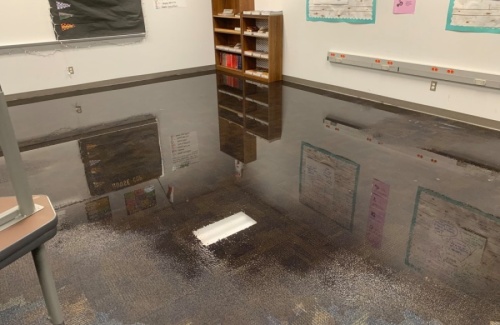 Standing water covering the floor in a carpeted classroom