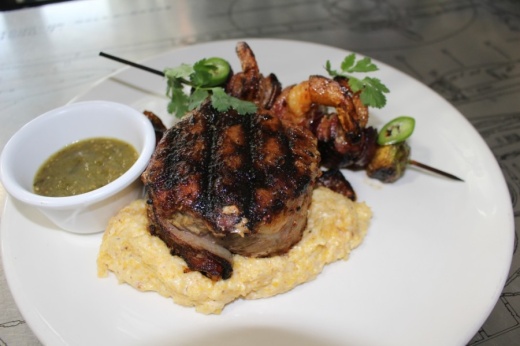 The bacon-wrapped center-cut ribeye, a special item not on the menu, ($28) is served on a bed of artismal grits and Brussels sprouts with fresh shrimp kabobs. (Eva Vigh/Community Impact Newspaper)