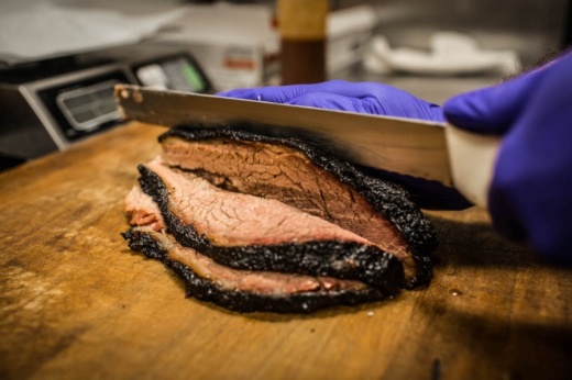 Photo of a knife cutting through brisket