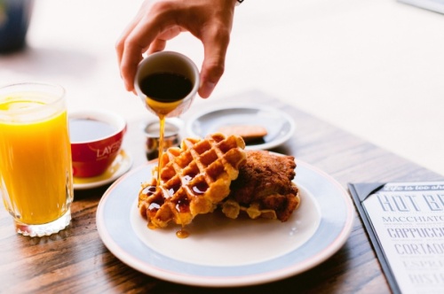 Chicken and waffles are served with syrup. (Courtesy Layered)
