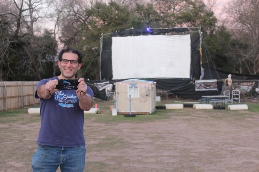 Josh Frank, owner of Blue Starlite Mini Urban Drive-in for more than a decade, holds up a Blue Starlite-branded mask. (Photo by Olivia Aldridge/Community Impact Newspaper)