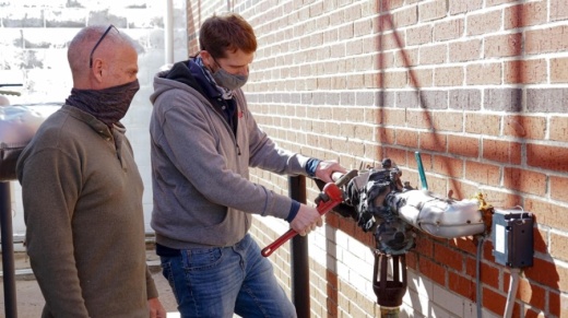 Frisco ISD Assistant Maintenance Director Benny Medcalf (left) and HVAC Supervisor Brent Pauling (right) work to repair a burst water line at Clark Middle School. The pipe, a component of the school’s heating and cooling system, burst during February's frigid temperatures while district campuses were disconnected from the state power grid. (Courtesy Frisco ISD)