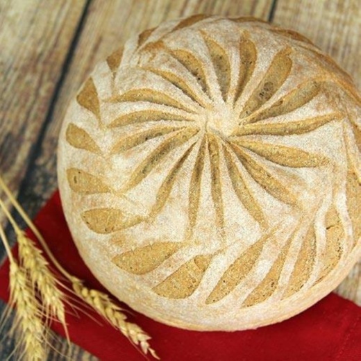 A round loaf of bread and wheat stalks