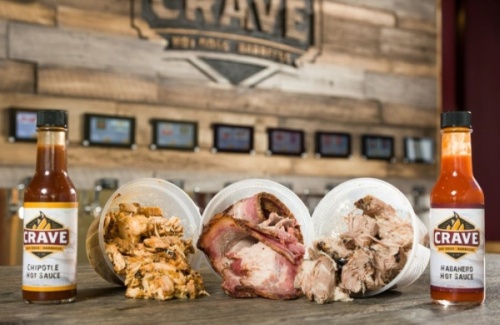 Menu items include barbecue dishes, hot dogs, Bratwurst, sausages, chicken wings, salads, craft beers and sides. (Courtesy Crave Hot Dogs and Barbecue)