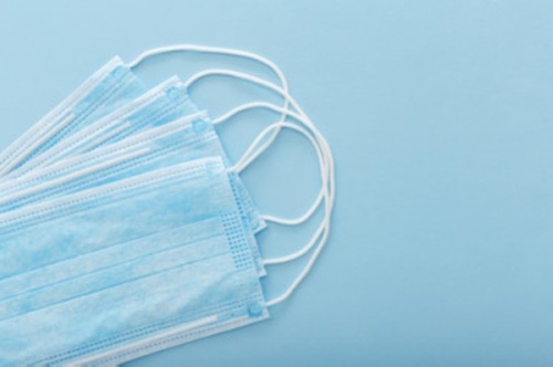 Photo of a stack of blue, disposable surgical masks
