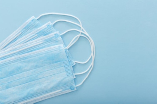 Photo of a stack of blue, disposable surgical masks