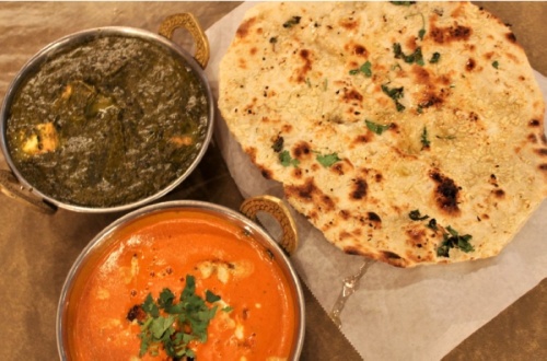 Two types of paneers, an Indian-style cottage cheese, •palak ($12.99) •and •butter masala ($12.99)•, are served with naan. (Photos by Sandra Sadek/Community Impact Newspaper)