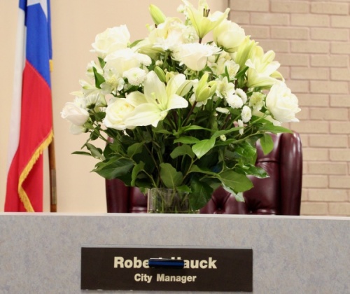 At a March 15 City Council meeting, a bouquet of flowers sat in the place of City Manger Rob Hauck. (Anna Lotz/Community Impact Newspaper)