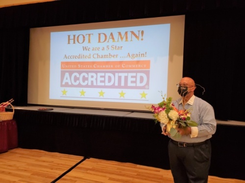 Phil Cunningham, chairman of the Grapevine Chamber of Commerce Board of Directors, presents flowers as the five-star accreditation is announced. (Courtesy Grapevine Chamber of Commerce)