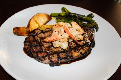 The prime 16-ounce ribeye is served with potatoes and asparagus as a main dish option. (Eva Vigh/Community Impact Newspaper)