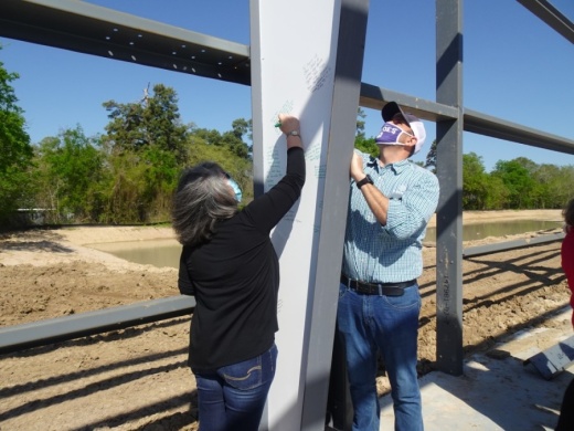 Cypress Assistance Ministries employees, board members and community partners were invited to leave messages and signatures on a beam in the organization's new building March 26. (Danica Lloyd/Community Impact Newspaper)
