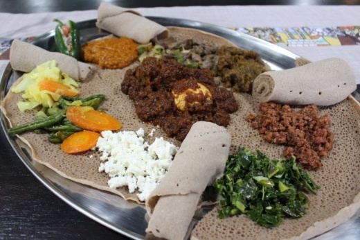 Ethiopian food is eaten communally, with groups gathering around a plate of food. (Photos by Olivia Lueckemeyer/Community Impact Newspaper)