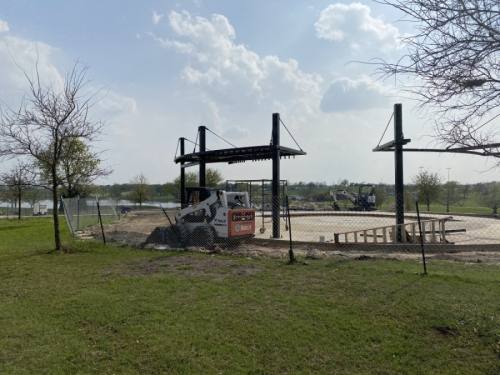 New amenities, including a basketball court and pergola structures with swings, are under construction at Old Settlers Park. (Haley Grace/Community Impact Newspaper)
