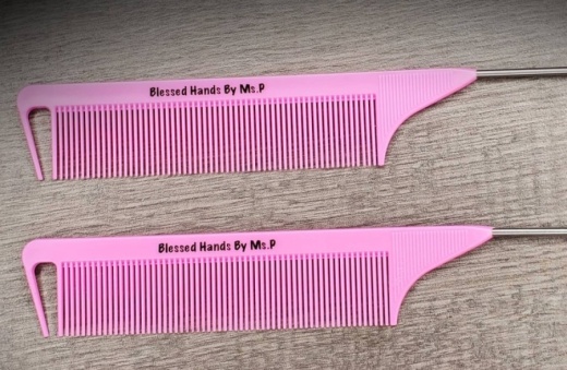 Two pink hair combs with the Blessed Hands by Ms. P logo on them
