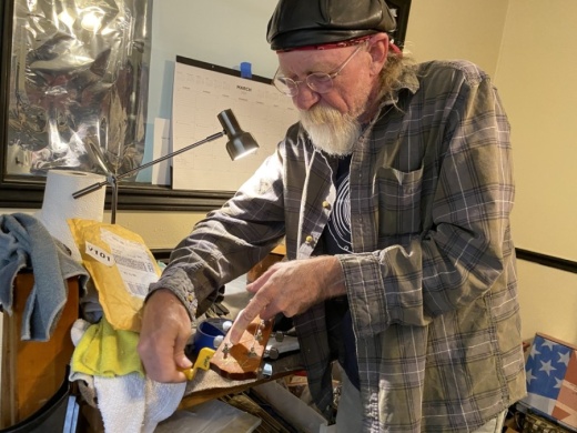 JAMS Music owner Ace Pepper restrings an acoustic guitar at his shop on Aquarena Springs Drive. (Brian Rash/Community Impact Newspaper)