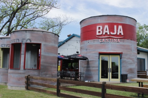 The exterior of a corrugated metal building blazoned with the word "BAJA."
