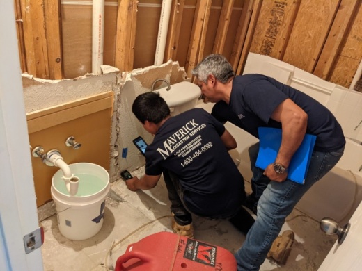 Maverick Remodeling and Construction employees use electronic gauges to determine how well a League City house that flooded from bust pipes is drying. (Jake Magee/Community Impact Newspaper)