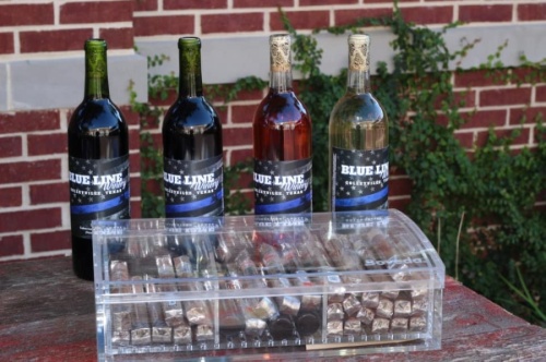 Four bottles of wine with Blue Line Winery labels and a clear box of cigars