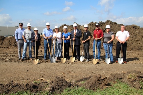 Andrew Cook, vice president of sales and marketing (fourth from left), stands next to President and CEO Kim Cook. The couple broke ground on the 42,000-square-foot office, showroom and distribution center May 27. (Megan Cardona/Community Impact Newspaper)