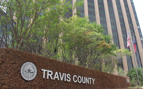Photo of a sign thta says Travis County outside a building