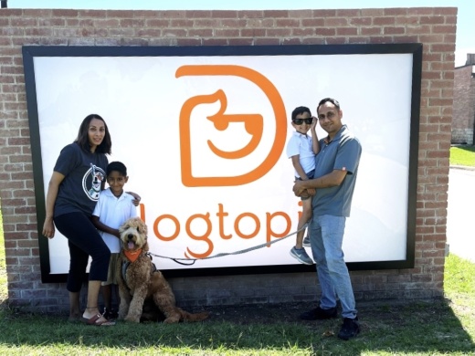 family poses by dogtopia sign