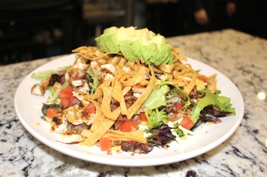 The Grogan salad consists of grilled chicken, pecan-smoked bacon, avocado, tomatoes, shredded cheese and corn tortilla strips. (Ally Bolender/Community Impact Newspaper)