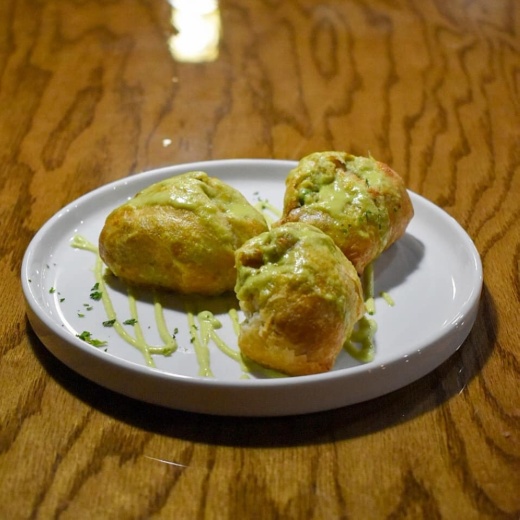 The spiced chicken puff pastries come with shredded chicken, garam masala and vegetables wrapped in a puff pastry and topped with creamy jalapeno sauce. (Courtesy Philipose's Kitchen & Bar)