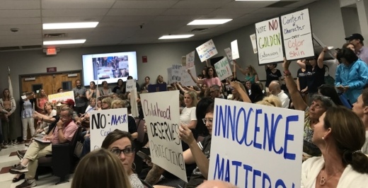 people with signs at meeting