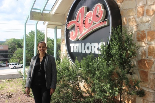 Photo of a woman in front of an "Ace Tailors" sign
