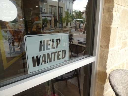 A 'help wanted' sign is posted in the window of Coco Crepes in Cypress. (Emily Jaroszewski/Community Impact Newspaper)
