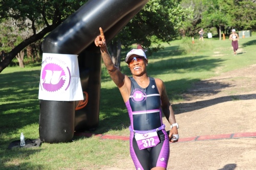 Athlete Lisa Thomas crosses the finish line June 13 at the Mighty Mujer Triathlon held at Lakeway City Park. The all-female race is one of four held nationwide to introduce women to triathlon and active lifestyles. (Courtesy Mighty Mujer Triathlon)