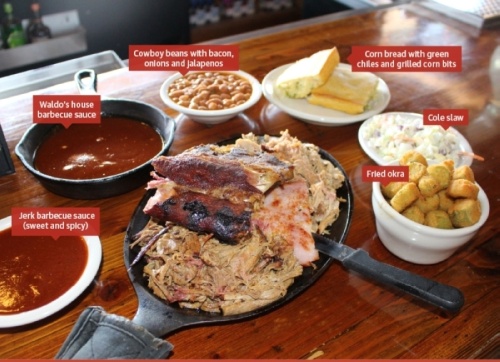 The Super Sampler ($23.99) comes with three choices of meats—shown are pulled beef, sliced ham and pulled pork—topped with a quarter-rack of baby back ribs. (Tom Blodgett/Community Impact Newspaper)