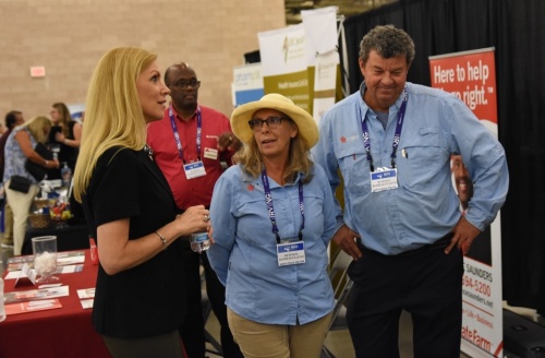 Congresswoman Beth Van Duyne speaks with Donna and Kurt Kauffman, owners of Colleyville-based Unique Landscaping, during the North Texas Job Fair. (Steven Ryzewski/Community Impact Newspaper)