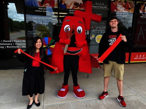 two people posing with the mathnasium mascot