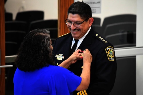 Onesimo Lopez officially receives his badge from his wife, Faby, to mark his promotion as Bellaire’s new chief of police during an Aug. 2 swearing-in ceremony. (Hunter Marrow/Community Impact Newspaper)