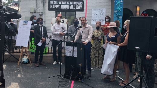 Rethink35 co-founder Adam Greenfield speaks during a news conference Sept. 1. Event organizers set up a pink line to represent how wide TxDOT's I-35 expansion would extend. (Benton Graham/Community Impact Newspaper)
