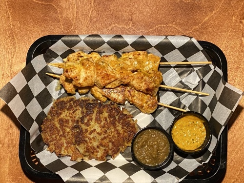 The Peruvian chicken skewers come with Kartoffel Puffers, jalapeno apple sauce and a side sauce. (Eric Weilbacher/Community Impact Newspaper)