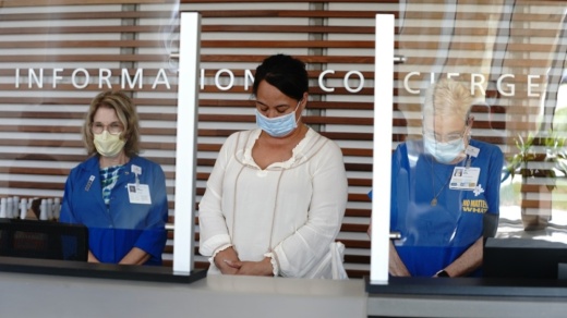 Photo of three women wearing masks with bowed heads