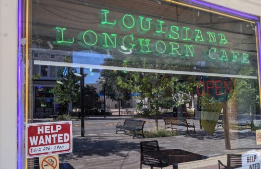 Signs seeking staff such as the one at Louisiana Longhorn Cafe in Round Rock have become more common in recent months. (Carson Ganong/Community Impact Newspaper