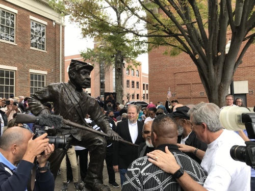 Members of the Fuller Story initiative gather around the newly unveiled statue. (Wendy Sturges/Community Impact Newspaper)