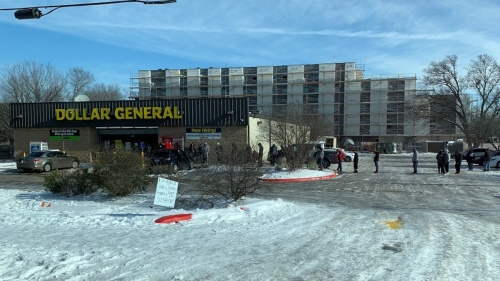 Photo of people waiting in line outside Dollar General in the snow
